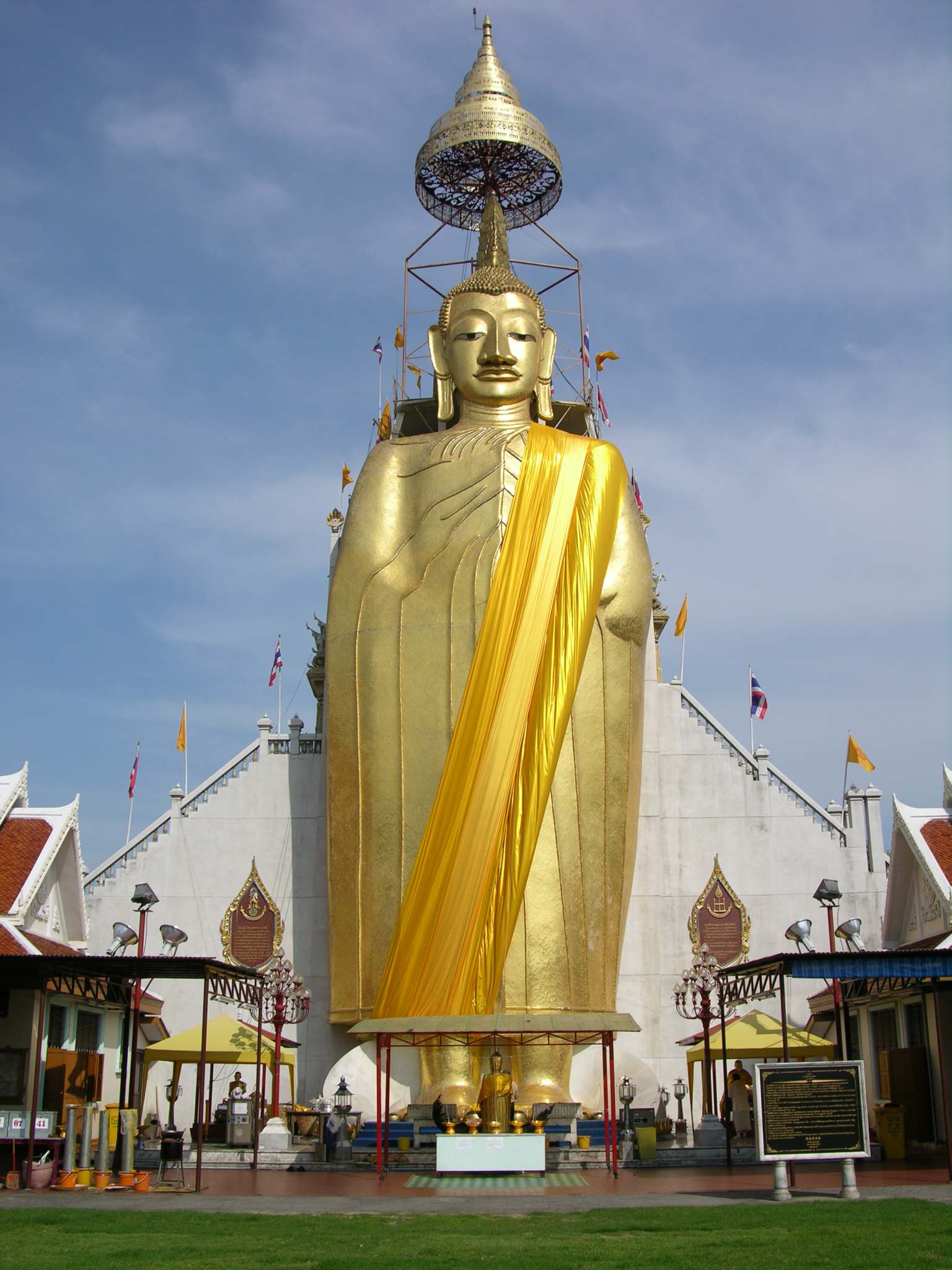Bangkok 02 01 Luang Pho To Buddha Statue We met a nice man on the way to the Grand Palace, who told us it was closed this morning. Although I had read of this scam, I was feeling great and compassionate and wanted to see how it played out. He mentioned that he could get us a private tuk-tuk tour to show us around some of the Bangkok sights for only a hundred Baht. We took him up on his offer. As long as you are willing to say no to the shopping portion of the tour, it�s great fun indeed. Our first stop was at Luang Pho To, a gigantic 32m x 11m statue of Buddha, built starting in 1867, and covered in 24k golden mosaics. The topknot of the Buddha image supposedly contains a relic of Lord Buddha brought from Sri Lanka.